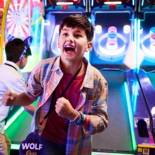 Child wearing a Wolf Pass while playing arcade games at Great Wolf Lodge.
