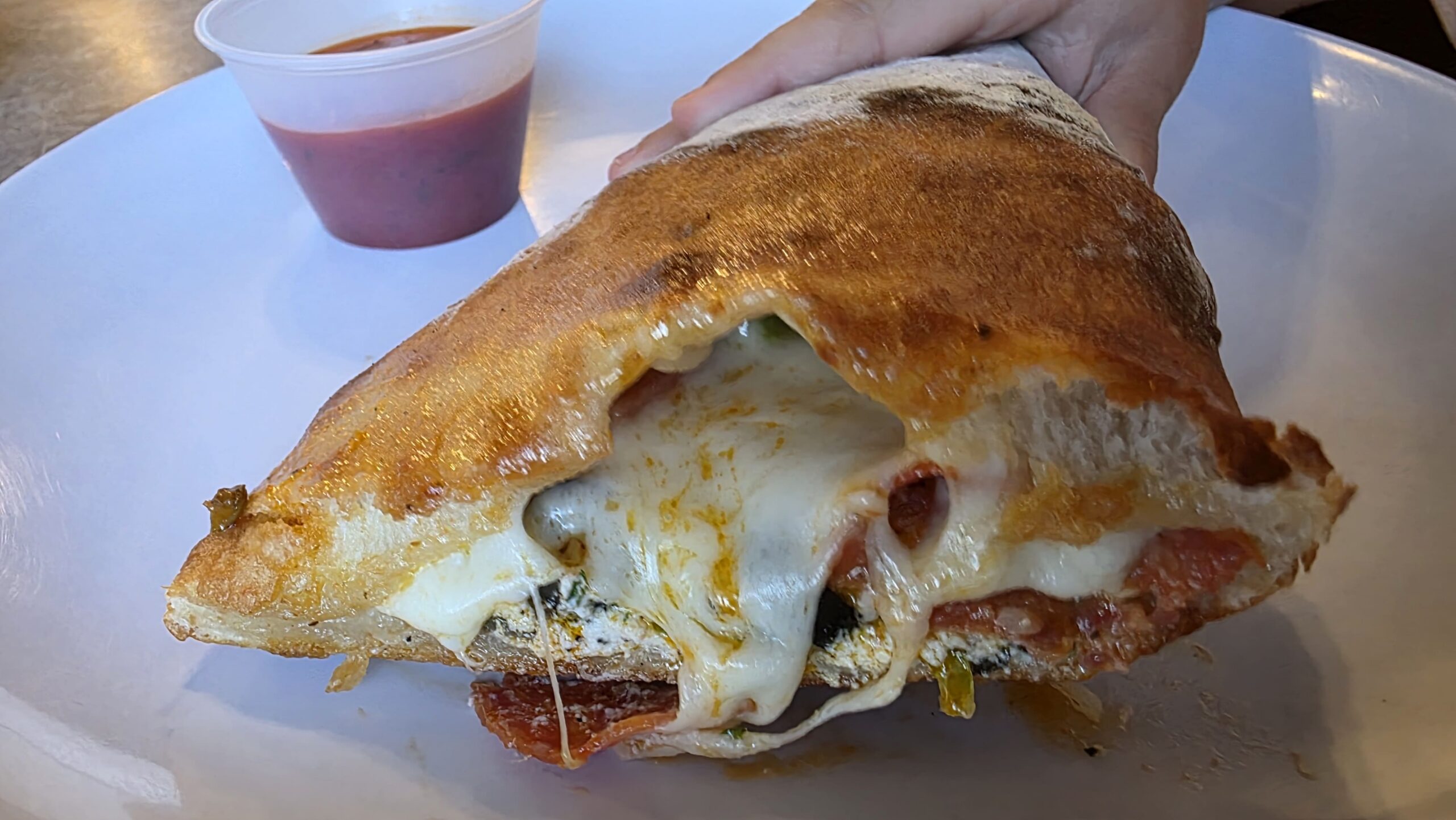 Freshly baked calzone with melted cheese and fillings at Ferrando’s Italian Pizzeria