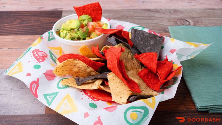Tacos served with colorful tortilla chips and fresh guacamole at El Tejano