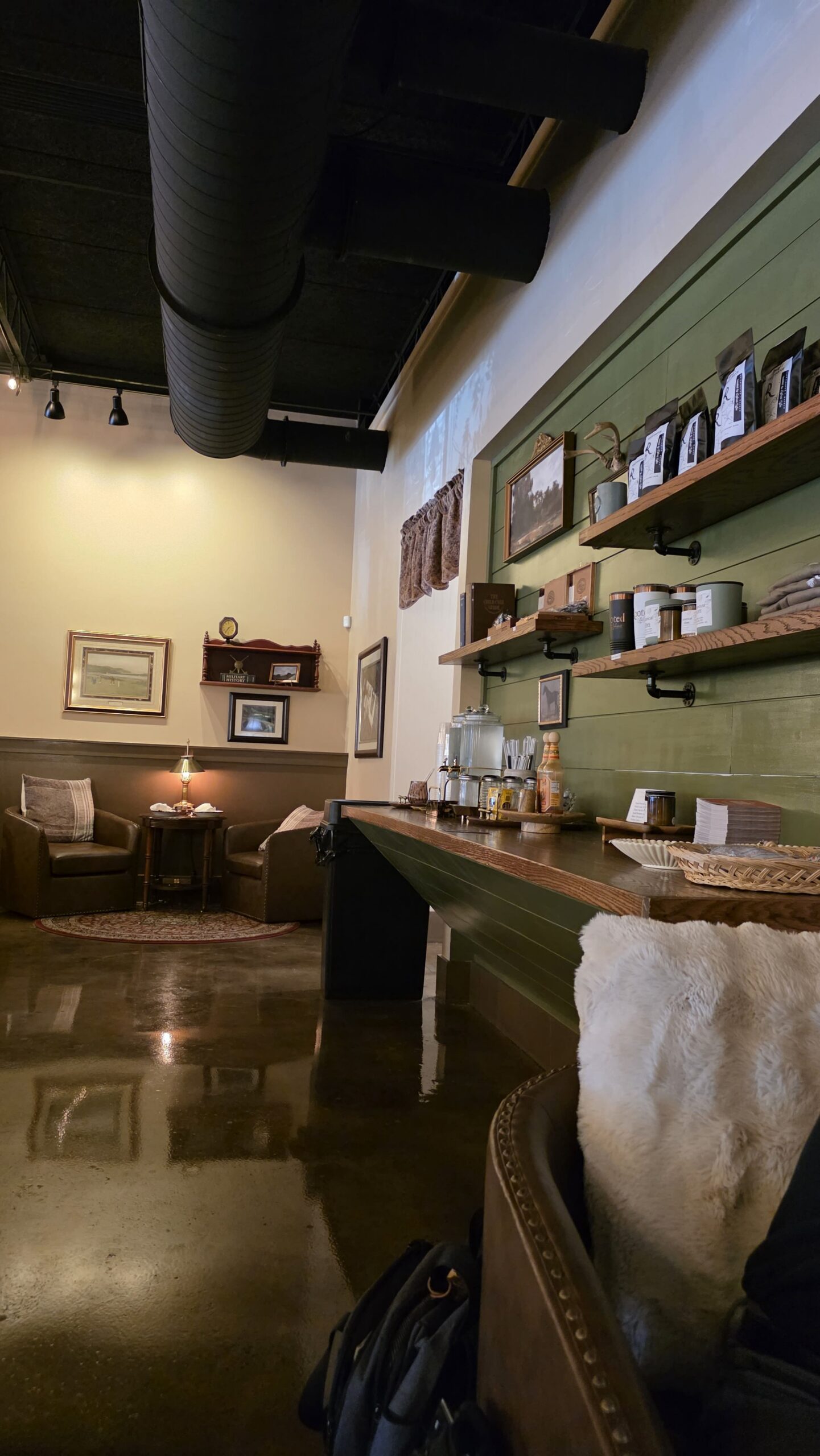 Cozy seating corner and retail coffee display inside Goat Kick Coffee