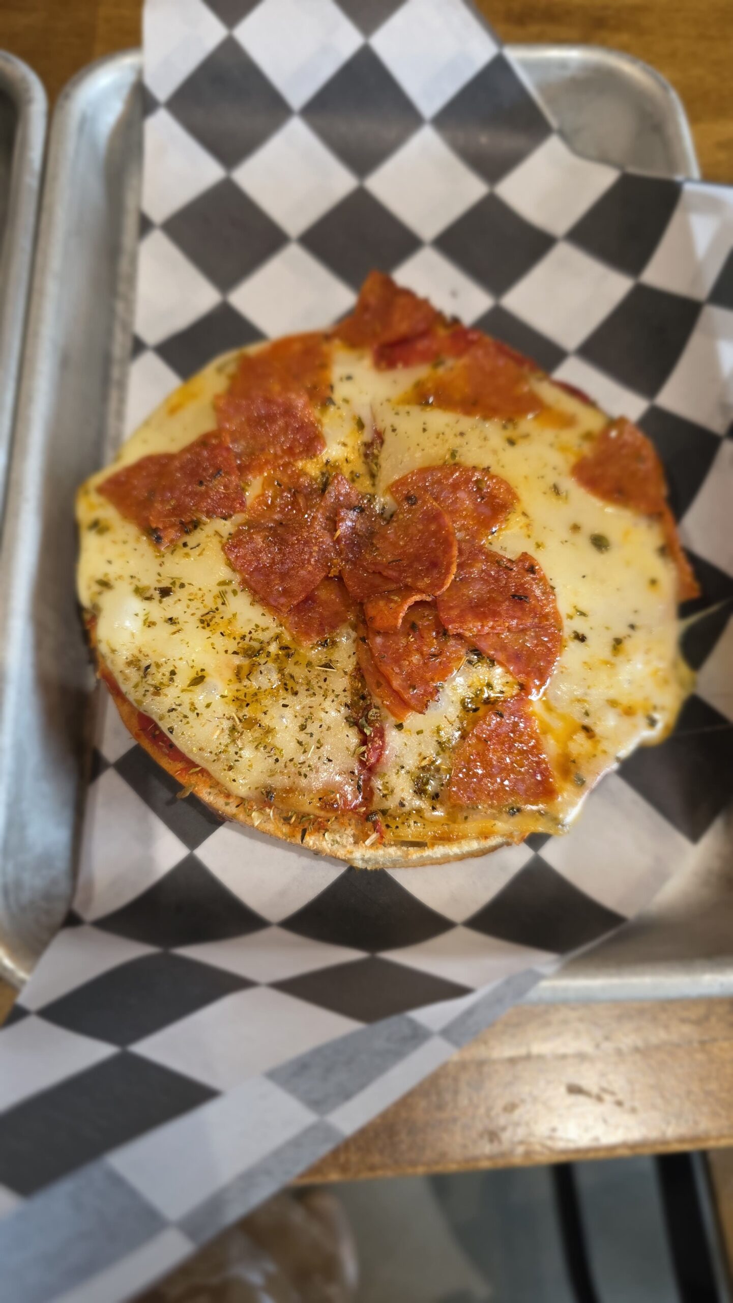 Pepperoni bagel pizza with melted cheese and herbs at Goat Kick Coffee in Evans, Georgia