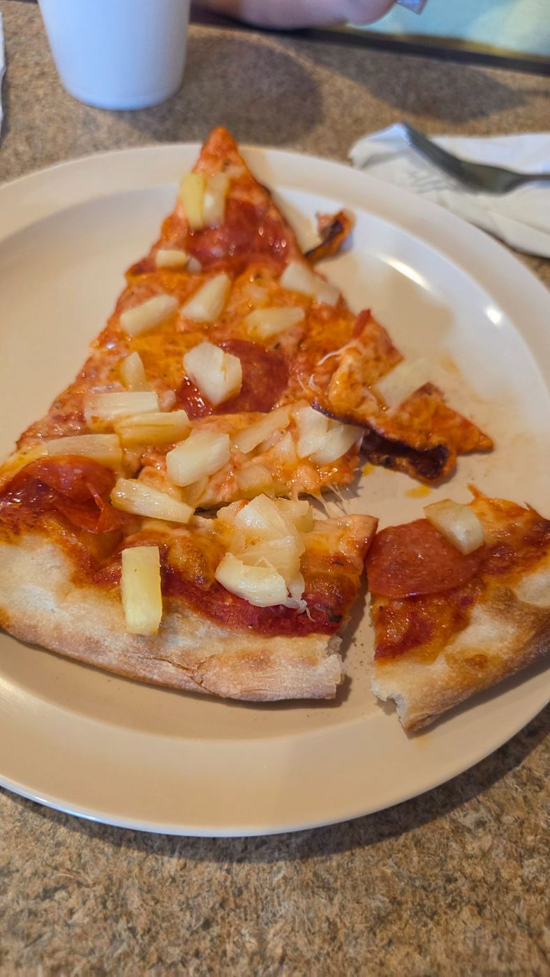 Pepperoni and pineapple pizza slice at Antonio's Italian Eatery in North